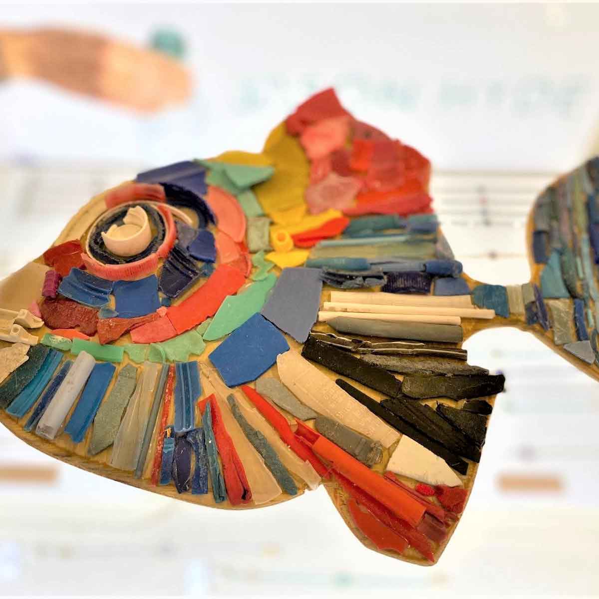 Colorful fish sculpture made from recycled materials, representing art and sustainability.