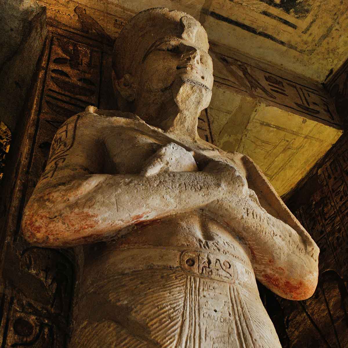 Ancient Egyptian statue with intricate carvings, showcasing historical art and culture within a temple.