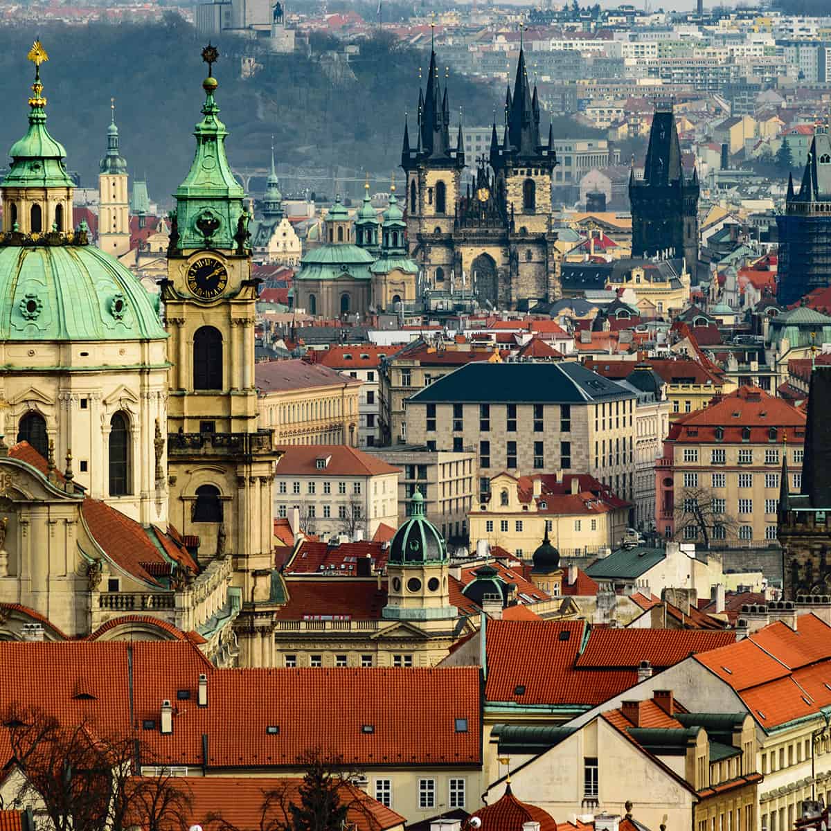 Stunning view of Prague's historic skyline featuring churches and vibrant rooftops.