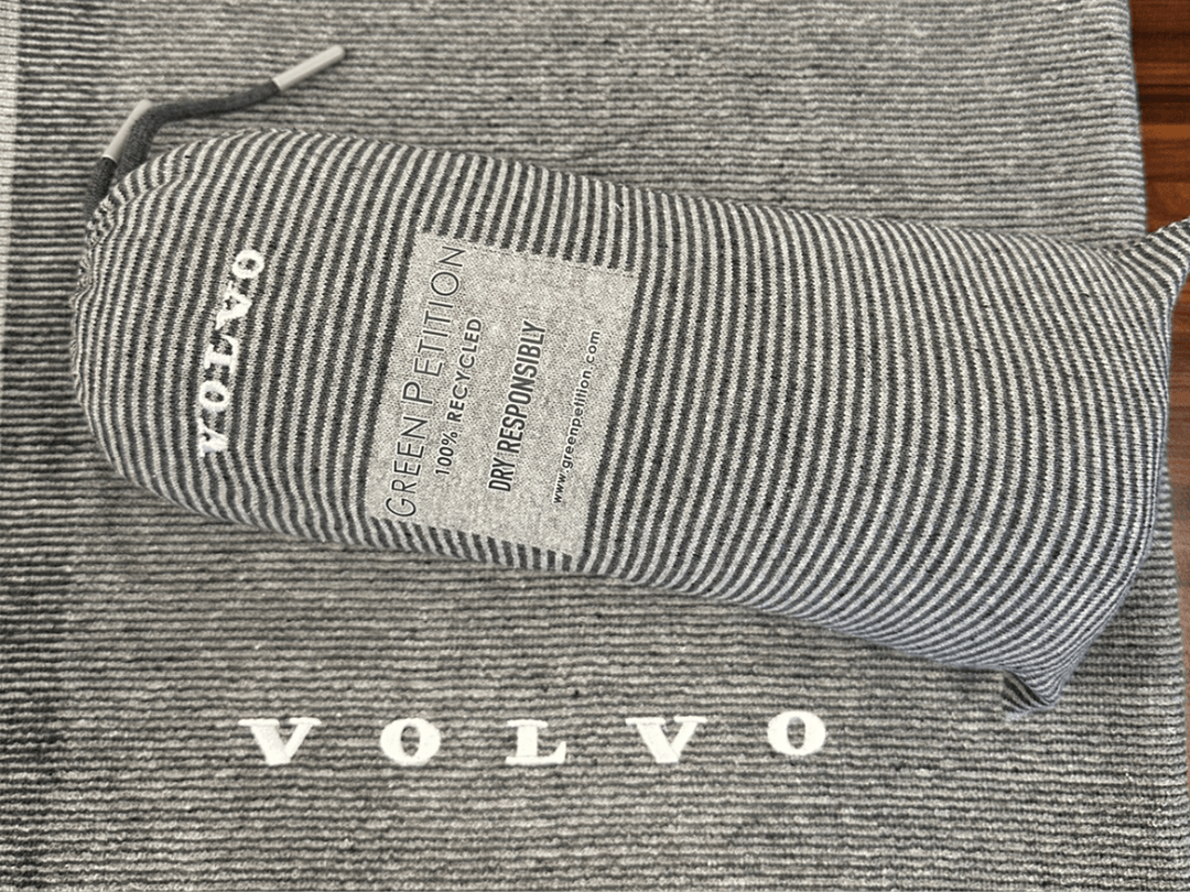 Volvo eco-friendly recycled fabric bag with 'Green Petition' label on striped background, showcasing sustainability effort.