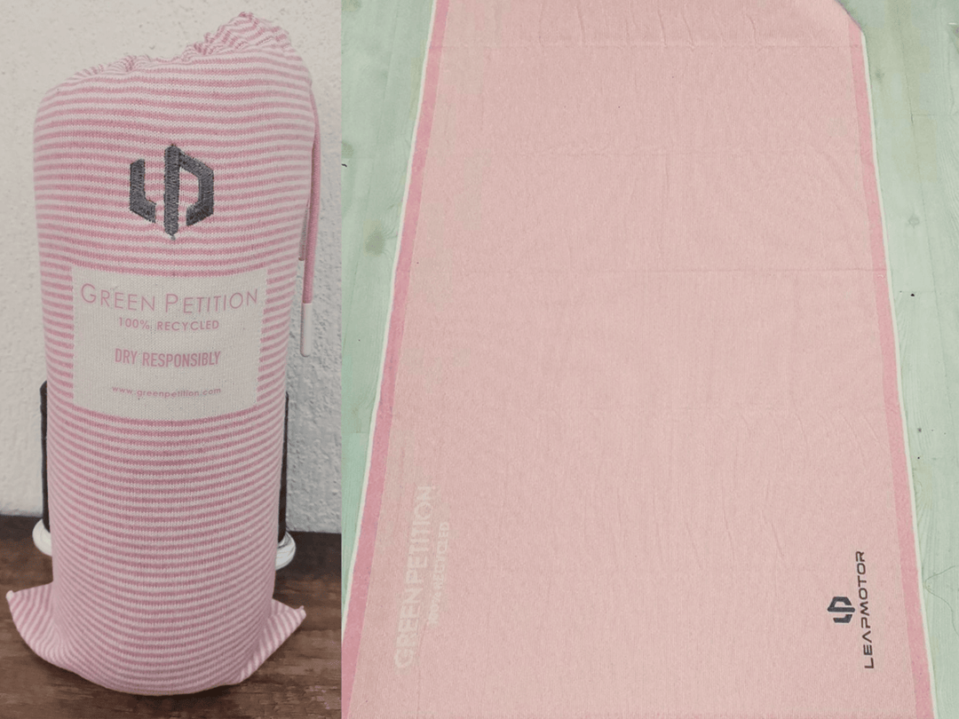 Eco-friendly pink towel wrapped in sustainable packaging, made from 100% recycled materials.