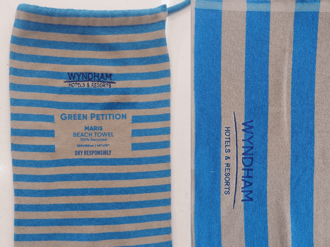 Wyndham Hotels beach towels in blue and gray stripes, promoting eco-friendly practices with 'Dry Responsibly' message.