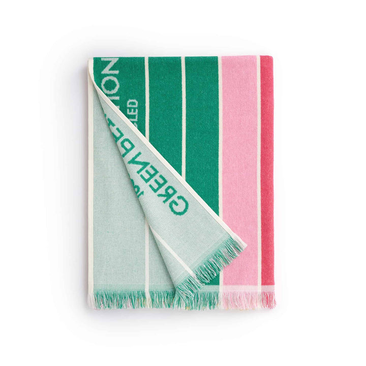 Ocean Nile Moss Beach Towel featuring eco-friendly design with green and pink stripes, folded neatly.