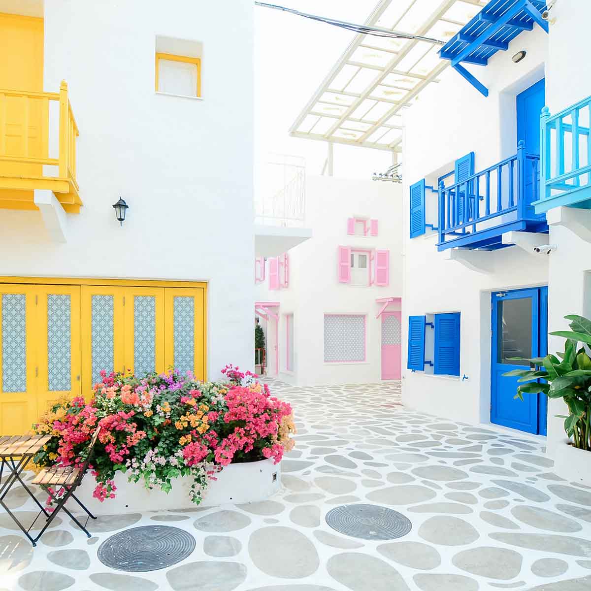 Charming European street with colorful buildings and vibrant flowers in a peaceful courtyard.