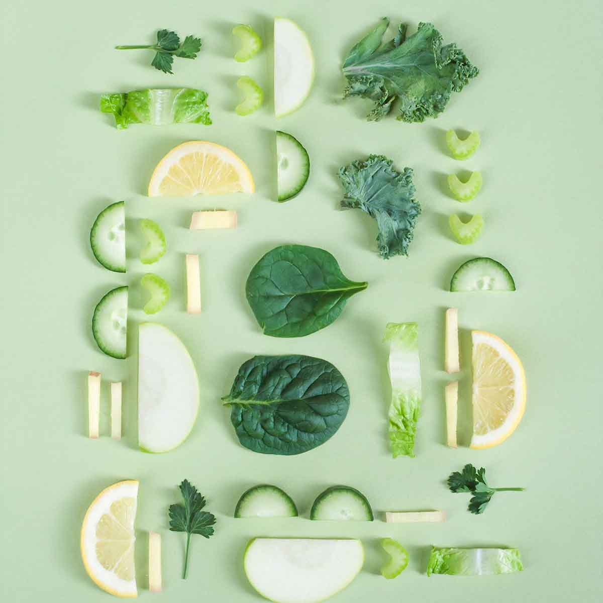 Colorful arrangement of fresh vegetables and fruits on a green background showcasing a zero waste lifestyle.
